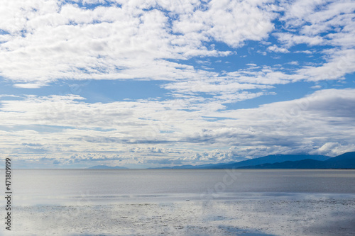 view to the Strait of Georgia from Iona Beach Regional Park azure water cloudy blue sky © olegmayorov