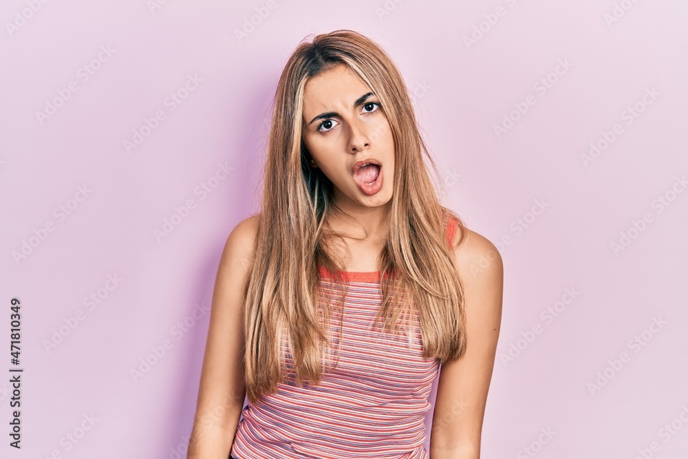 Beautiful hispanic woman wearing casual summer t shirt in shock face, looking skeptical and sarcastic, surprised with open mouth Beautiful hispanic woman wearing casual summer t shirt in shock face, looking skeptical and sarcastic, surprised with open mouth