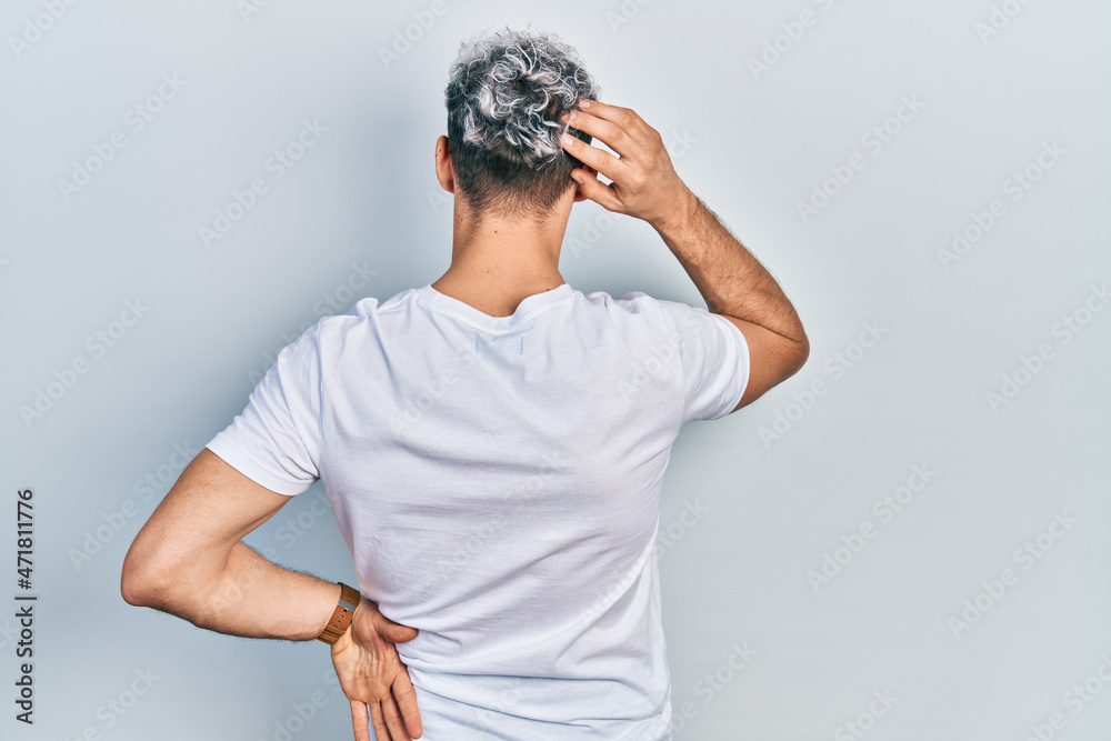 Young hispanic man with modern dyed hair wearing white t shirt and glasses backwards thinking about doubt with hand on head Young hispanic man with modern dyed hair wearing white t shirt and glasses backwards thinking about doubt with hand on head