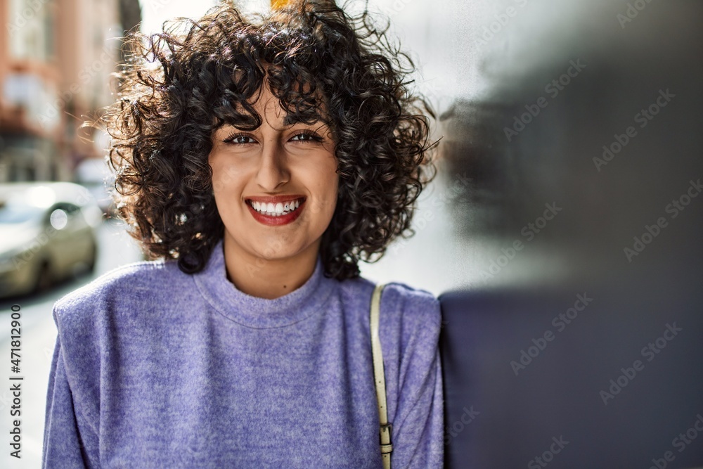 Young middle east woman smiling confident leaning on the wall at street Young middle east woman smiling confident leaning on the wall at street