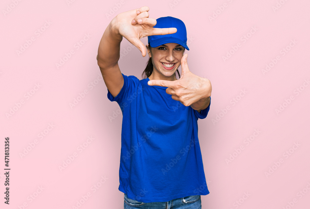 Young hispanic girl wearing delivery courier uniform smiling making frame with hands and fingers with happy face. creativity and photography concept. Young hispanic girl wearing delivery courier uniform smiling making frame with hands and fingers with happy face. creativity and photography concept.