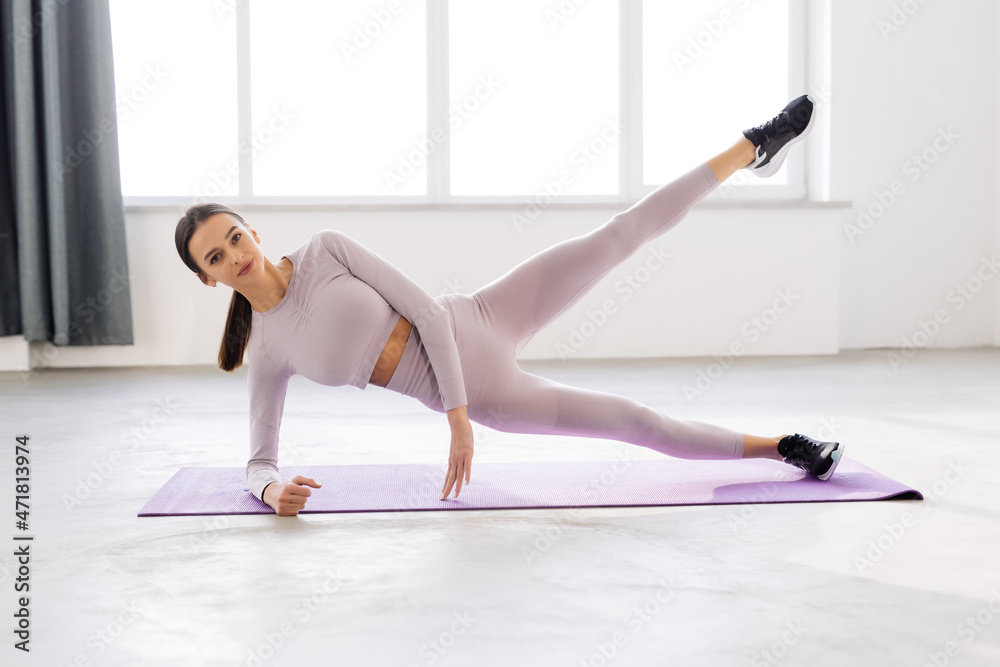 Obraz premium fitness, sport, training and lifestyle concept. Smiling woman doing exercises on mat in gym