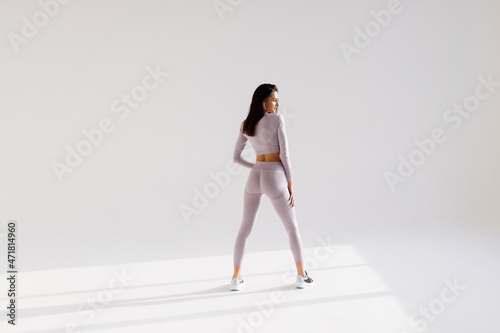 Full length portrait of a happy sports woman posing on a white background