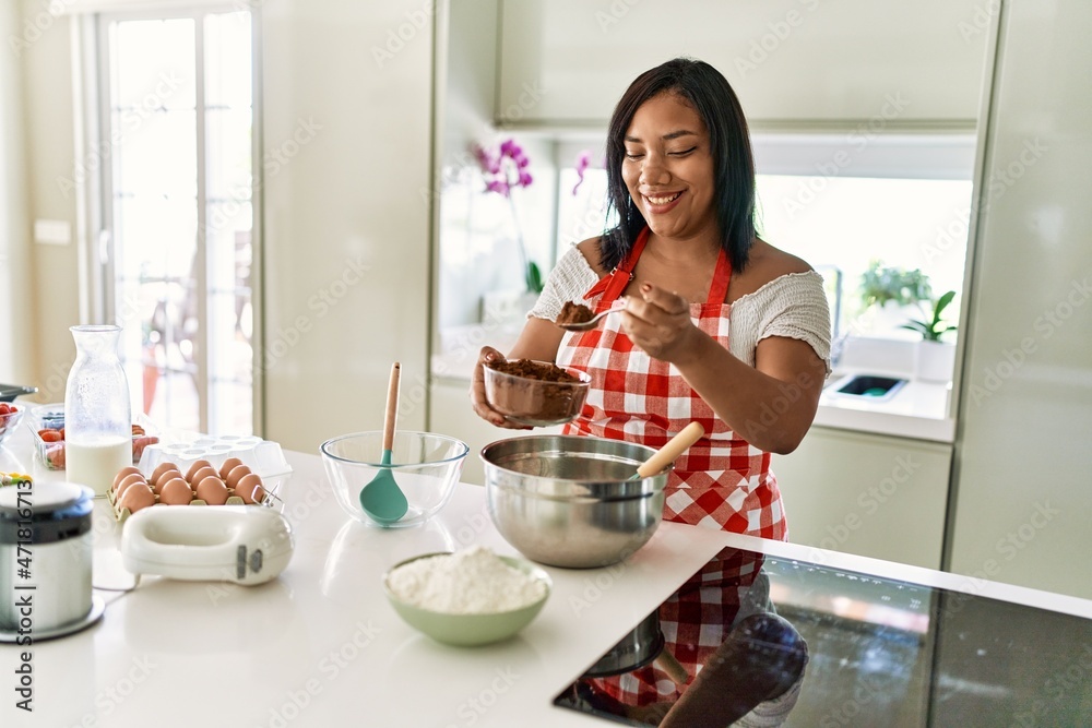 Hispanic brunette woman preparing chocolate cake at the kitchen Hispanic brunette woman preparing chocolate cake at the kitchen