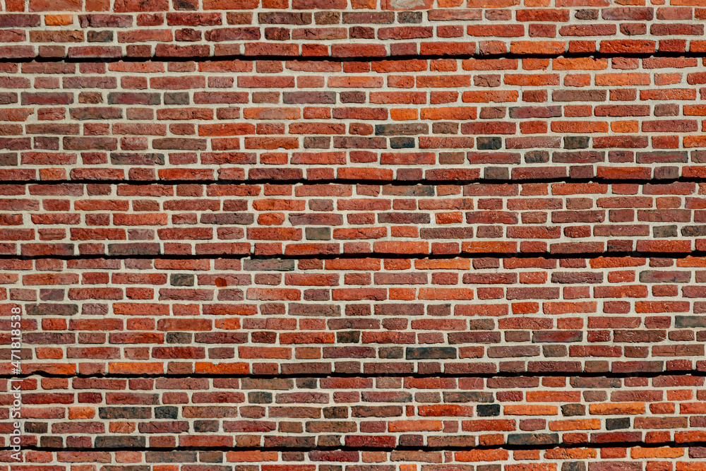 A wide brick blank wall of an old building. Uneven brickwork on a large wall. A wide brick blank wall of an old building. Uneven brickwork on a large wall.