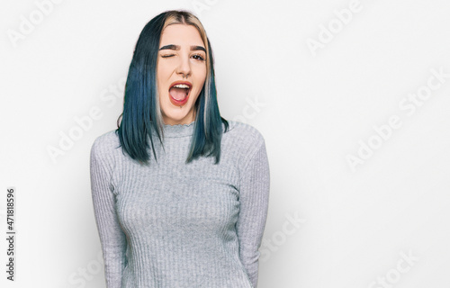 Young modern girl wearing casual sweater winking looking at the camera with sexy expression, cheerful and happy face. © Krakenimages.com