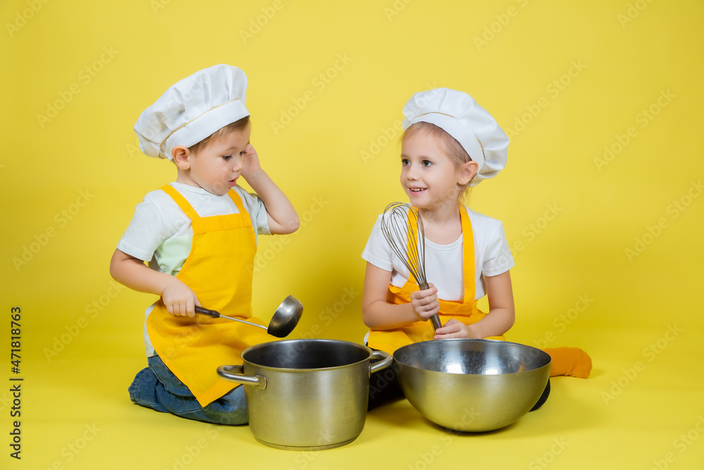 kids in apron and chef's hat sitting on the floor with a bowl and whisk kids in apron and chef's hat sitting on the floor with a bowl and whisk
