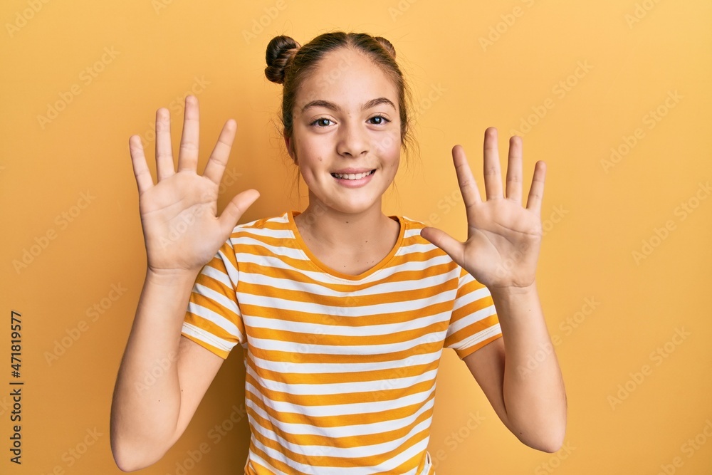 Beautiful brunette little girl wearing casual striped t shirt showing and pointing up with fingers number ten while smiling confident and happy. Beautiful brunette little girl wearing casual striped t shirt showing and pointing up with fingers number ten while smiling confident and happy.