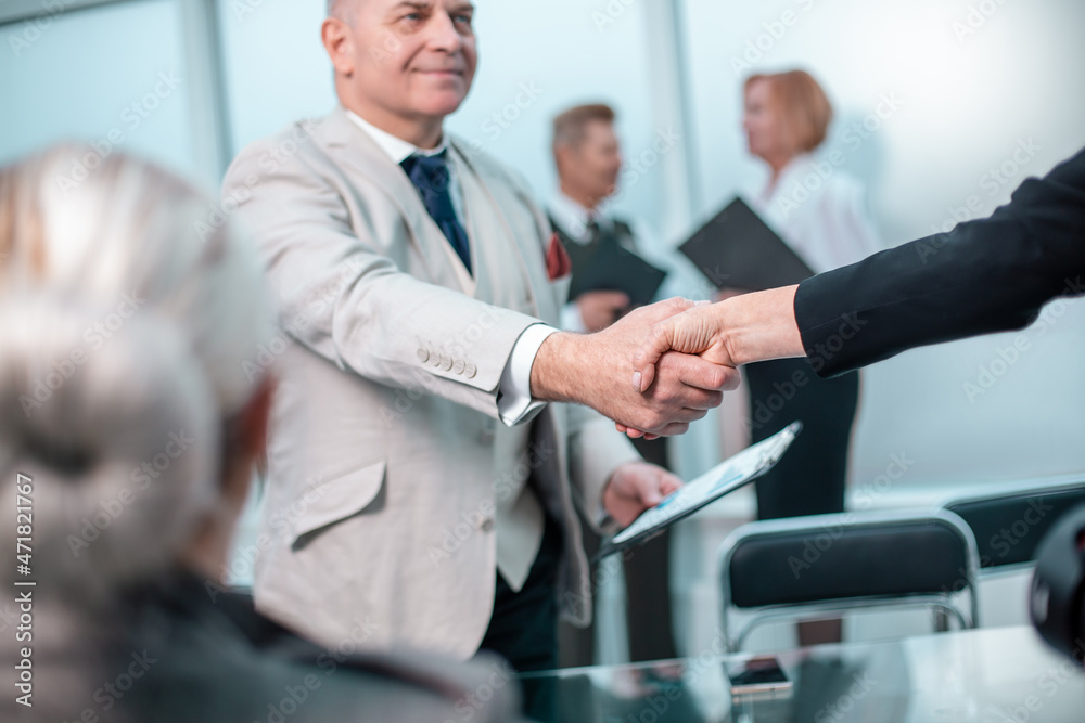 confident businessman shaking hands with his business partner. confident businessman shaking hands with his business partner.
