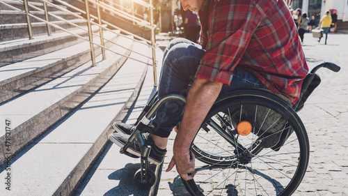 Bild auf Leinwand Young man with a physical disability in a wheelchair in front of the stairs