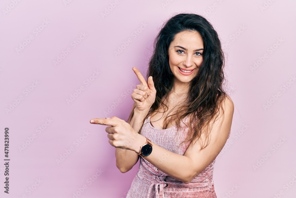 Young hispanic woman wearing casual clothes smiling and looking at the camera pointing with two hands and fingers to the side. Young hispanic woman wearing casual clothes smiling and looking at the camera pointing with two hands and fingers to the side.