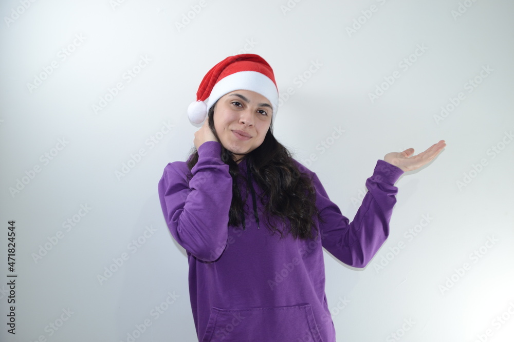 Girl in red christmas hat poses in studio