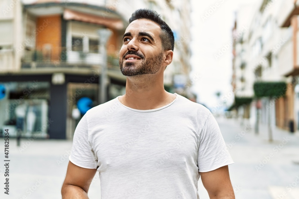 Young hispanic man smiling confident walking at street