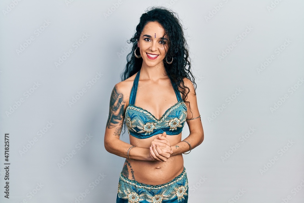 Young woman wearing bindi and traditional belly dance clothes with hands together and crossed fingers smiling relaxed and cheerful. success and optimistic Young woman wearing bindi and traditional belly dance clothes with hands together and crossed fingers smiling relaxed and cheerful. success and optimistic