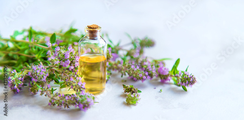 Thyme essential oil in a small bottle. Selective focus.