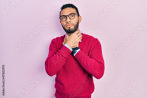 Hispanic man with beard wearing business shirt and glasses shouting suffocate because painful strangle. health problem. asphyxiate and suicide concept.
