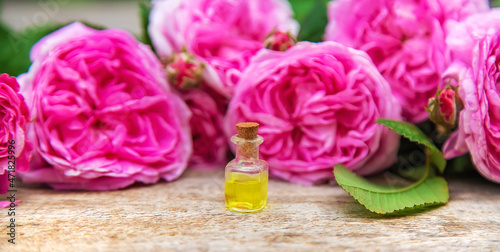 Rose essential oil in a small bottle. Selective focus.