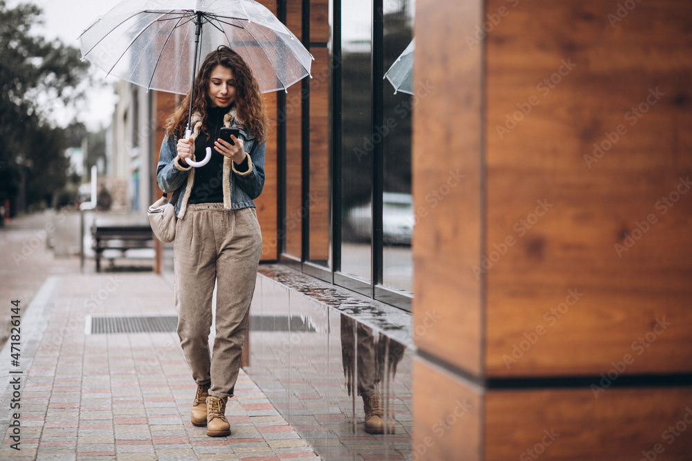 Woman walking under the umbrella in a rainy weather