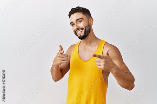 Young handsome man with beard standing over isolated background pointing fingers to camera with happy and funny face. good energy and vibes. © Krakenimages.com