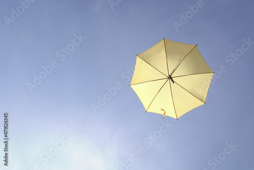 Yellow umbrella on blue sky. Copy space.