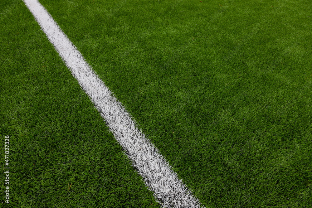 Photo of a green synthetic grass sports field with white line shot from above