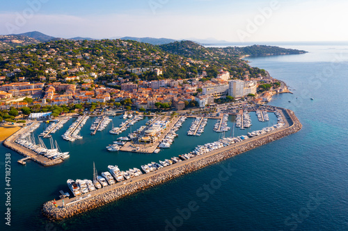 Aerial panoramic view of French commune of Sainte-Maxime on shore of Gulf of Saint-Tropez overlooking large marina on sunny summer day, Var department