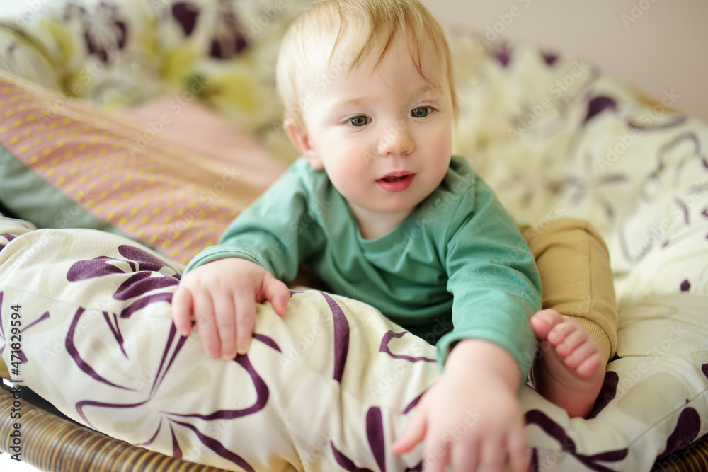 Adorable baby boy sitting in a chair by the window. Adorable baby boy sitting in a chair by the window.
