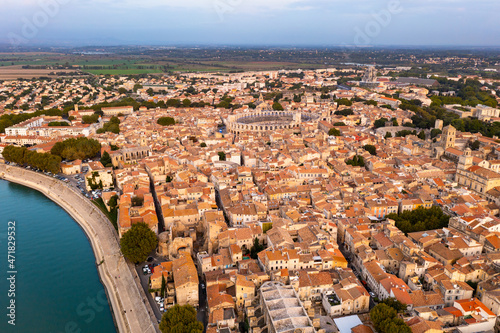 Bird's eye view of Arles, France. Residential buildings with tiled rooftops and Arles Amphitheatre visible from above.