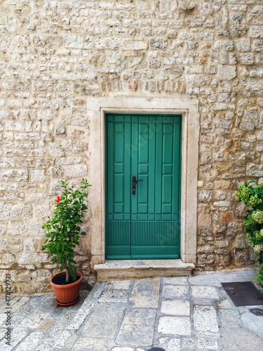 Green door in the house built of a shell-rock stones