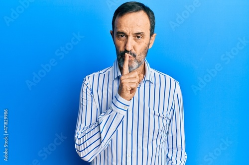 Middle age hispanic man wearing casual clothes asking to be quiet with finger on lips. silence and secret concept. © Krakenimages.com
