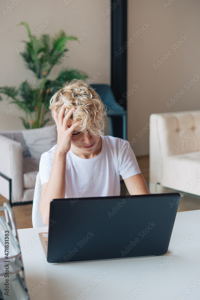 teenager is studying at the laptop. Doing homework. Remote school. teenager is studying at the laptop. Doing homework. Remote school.