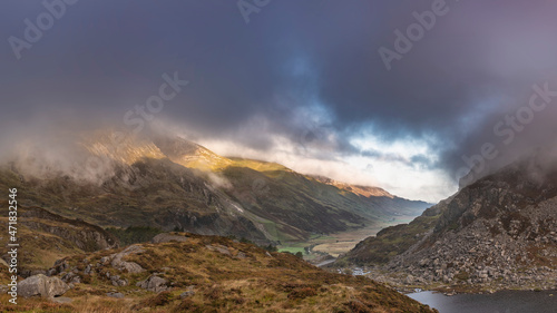 Fototapeta Naklejka Na Ścianę i Meble -  Epic Autumn landscape image of view along Nant Fracon valley in Snowdonia National Park with dramatic evening sky and copy space