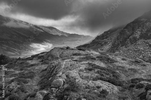 Black and white Epic Autumn landscape image of view along Nant Fracon valley in Snowdonia National Park with dramatic evening sky and copy space
