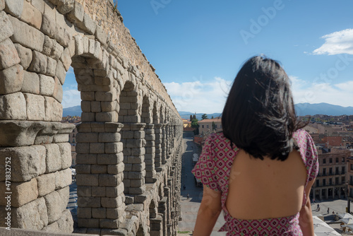 woman at Segovia acueducto viewpoint during vacation in Spain - young happy woman visiting world heritage aqueduct in Segovia enjoying holidays travel