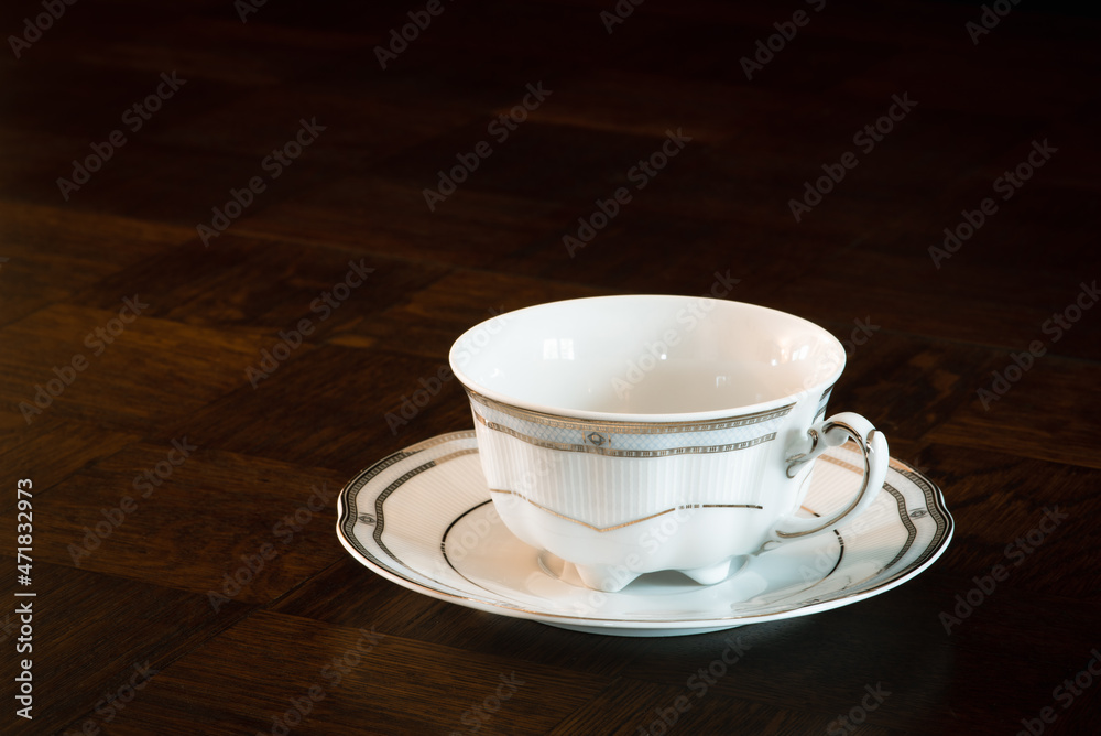 Porcelain empty cup for tea or coffee on wooden dark table Porcelain empty cup for tea or coffee on wooden dark table
