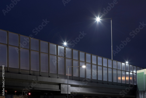 road overpass with night lighting and noise barrier