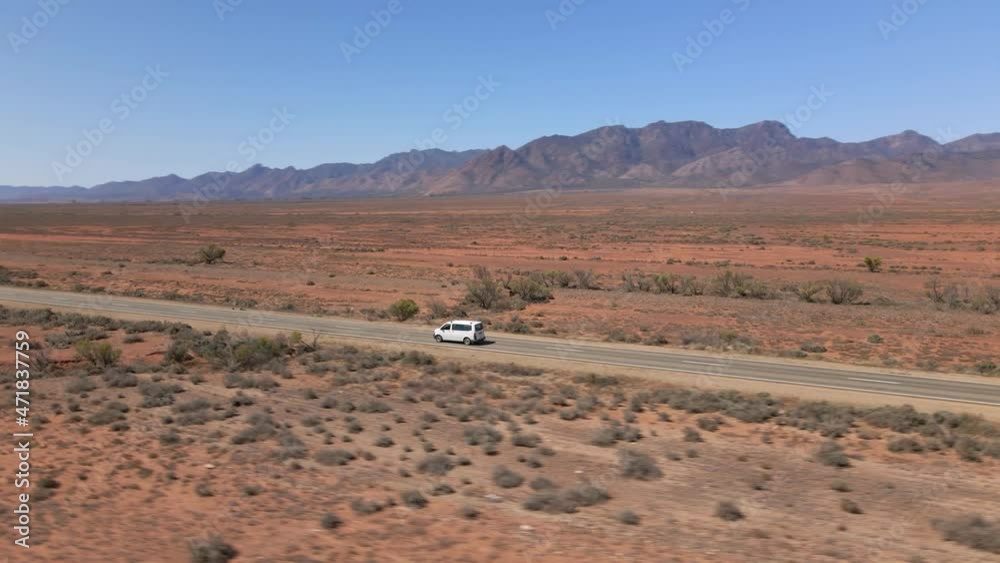 Aerial parallax shot over White caravan driving on countryside road, Outback Scenery Aerial parallax shot over White caravan driving on countryside road, Outback Scenery