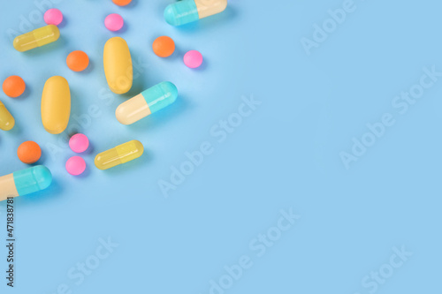 Assorted medicine pills, capsules and tablets on blue background with copyspace. Immune system vitamins and supplemets