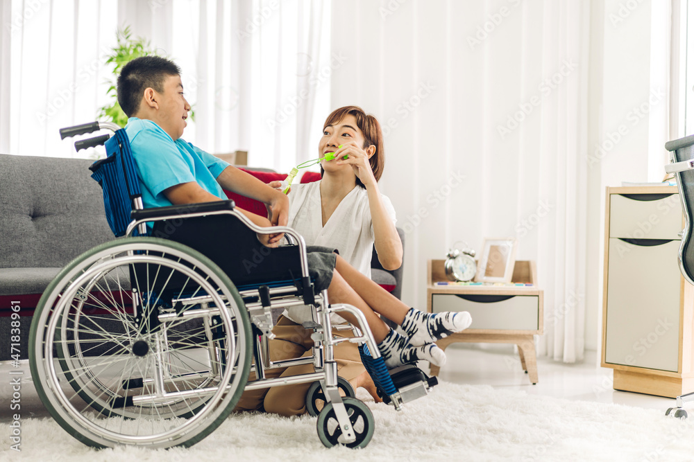 Portrait of asian physiotherapist carer helping and playing with special disabled child health problem by doing exercises sitting in wheelchair in rehabilitation clinic.disability care concept Portrait of asian physiotherapist carer helping and playing with special disabled child health problem by doing exercises sitting in wheelchair in rehabilitation clinic.disability care concept