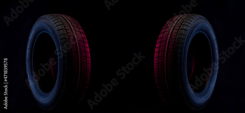 winter wheel for a car on a stylish black and blue red background