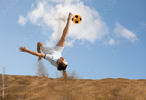 Fototapeta Naklejka Na Ścianę i Meble -  The man footballers are desperately playing beach soccer on sand on a sunny day