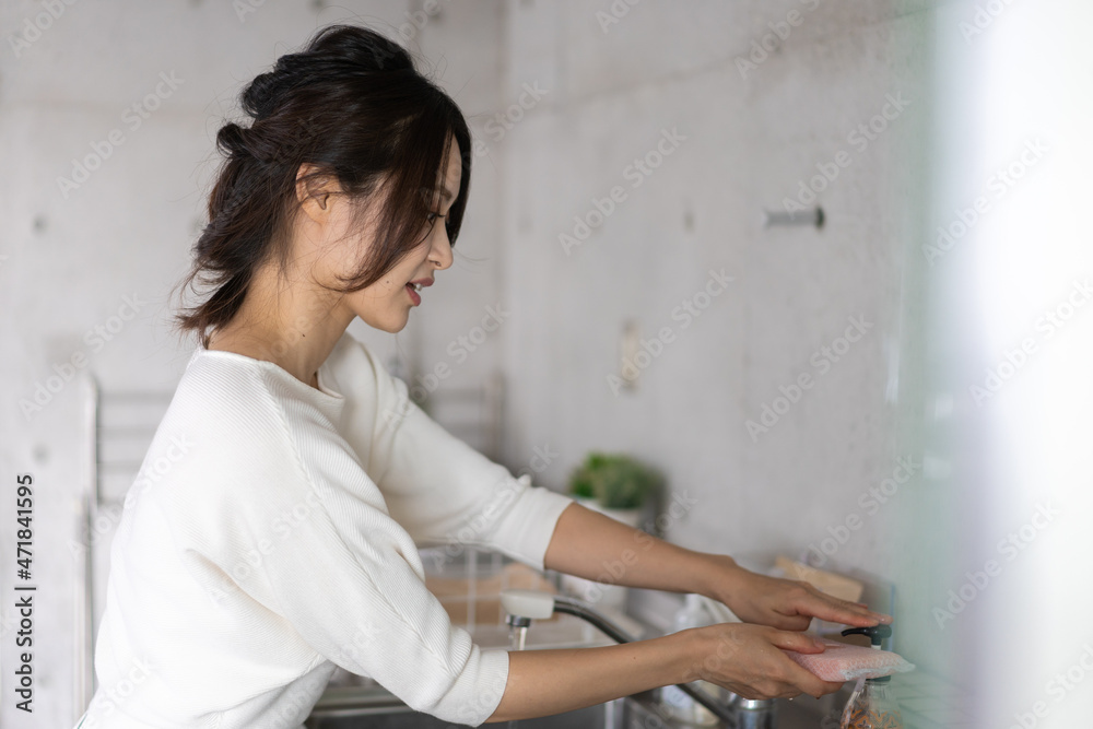 家で洗い物をする若い女性