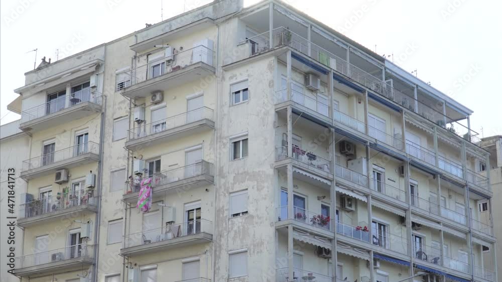 Old, faded, and deteriorated apartment building in a city, tilt shot Old, faded, and deteriorated apartment building in a city, tilt shot