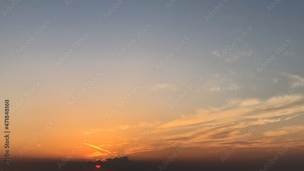 Orange sunset with blue sky and soft clouds Orange sunset with blue sky and soft clouds