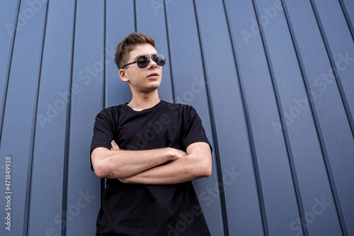 Portrait of a fashion young man leaning against a blue wall © romaset