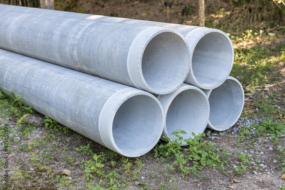 Concrete Drainage Pipe on a Construction Site. Concrete drainage pipes stacked for construction. Concrete drainage tube on construction site near high way road Concrete Drainage Pipe on a Construction Site. Concrete drainage pipes stacked for construction. Concrete drainage tube on construction site near high way road