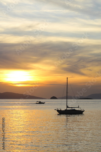 Alone sailboat at sunset. Atmospheric seascape with orange sun © bt1976