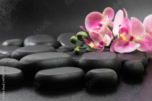 Spa stones  and flowers on black background .