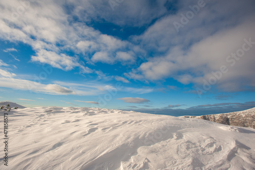Panorama of snow-capped mountains, snow and clouds on the horizon