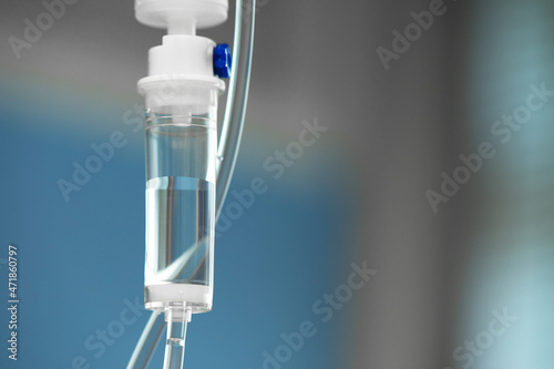 Close-up of IV tube. Action. Dropper with drug slowly dripping down tube. IV tubes for sick patient after surgery.